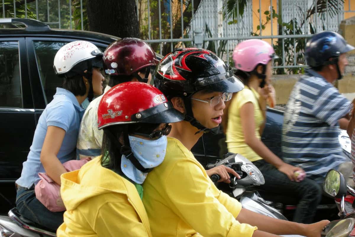 Conducteurs et passagers casqués sur des scooters dans la circulation d'Hô-Chi-Minh-Ville