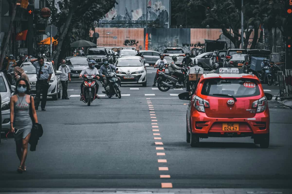 Circulation de scooters, de voitures et de taxis dans une rue de ville vietnamienne