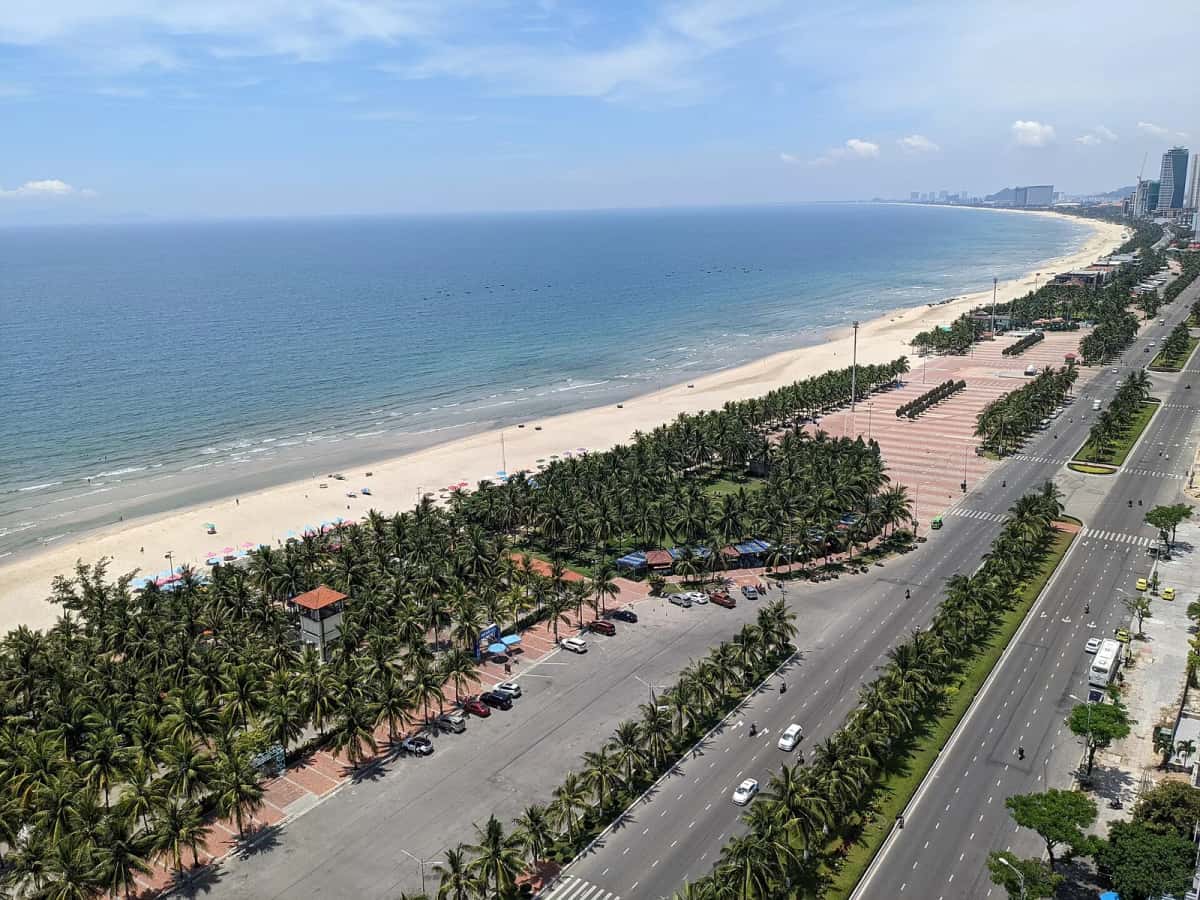Vue aérienne de la plage de Mỹ Khê bordée de cocotiers et du boulevard du front de mer, Da Nang