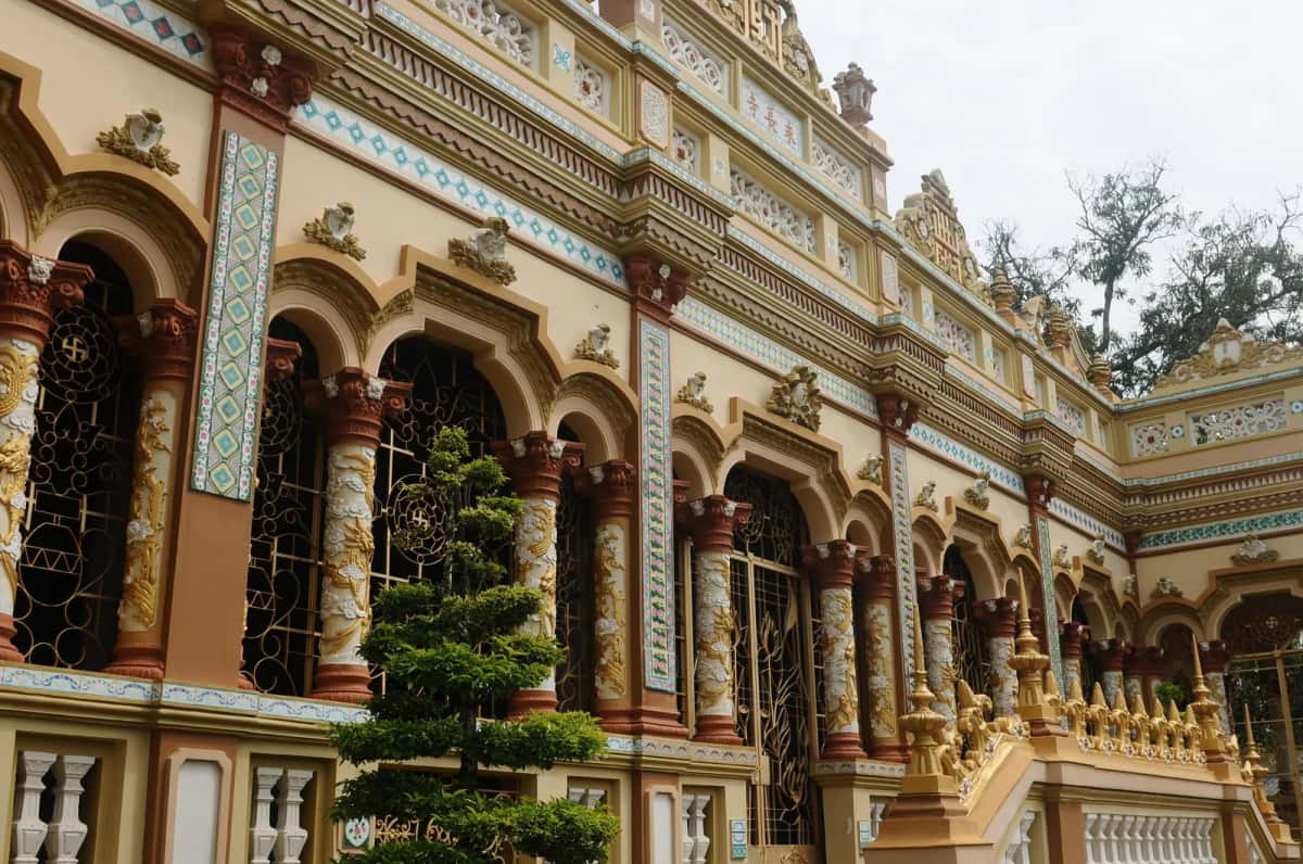 Façade ornée de la pagode Vĩnh Tràng à Mỹ Tho, colonnes sculptées de dragons et décors de céramique
