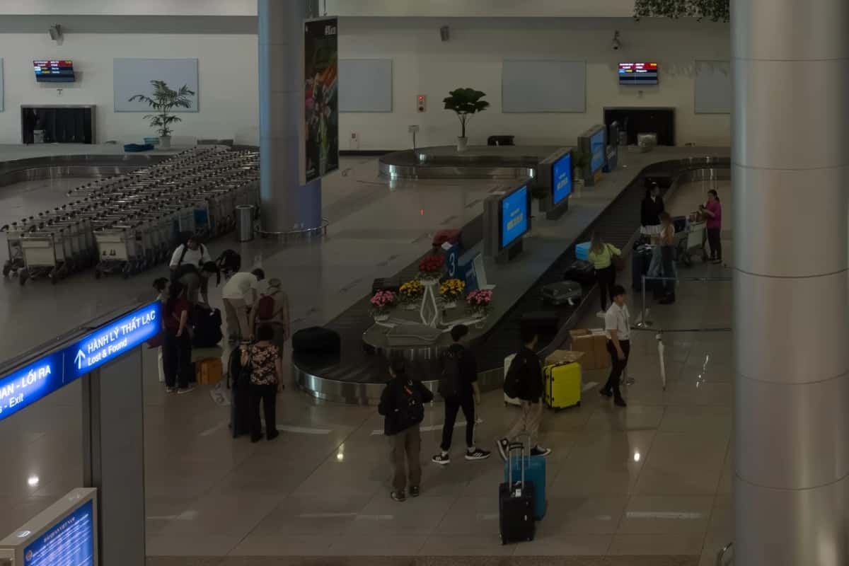 Hall des arrivées internationales de l'aéroport de Tan Son Nhat à Hô Chi Minh-Ville, voyageurs devant le tapis à bagages