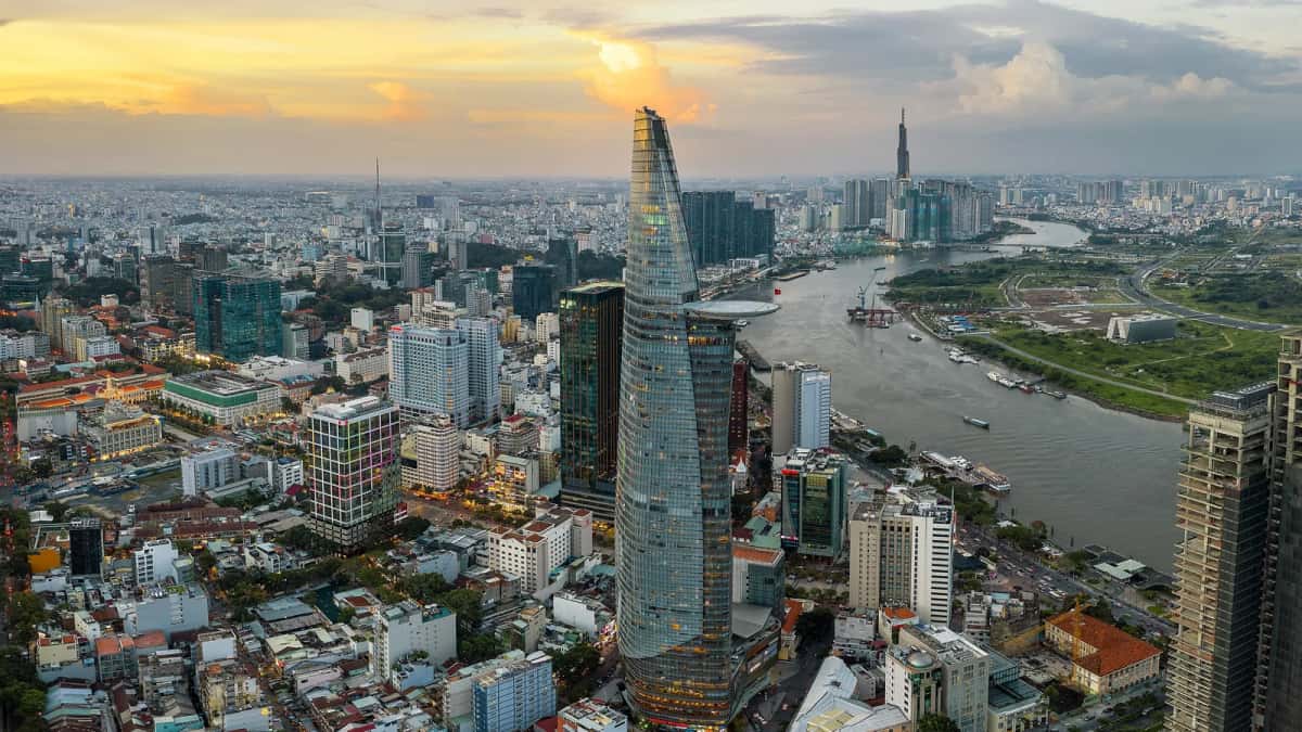 Vue aérienne de Hô Chi Minh-Ville au coucher du soleil : la tour Bitexco, la rivière Saigon et la Landmark 81 au fond