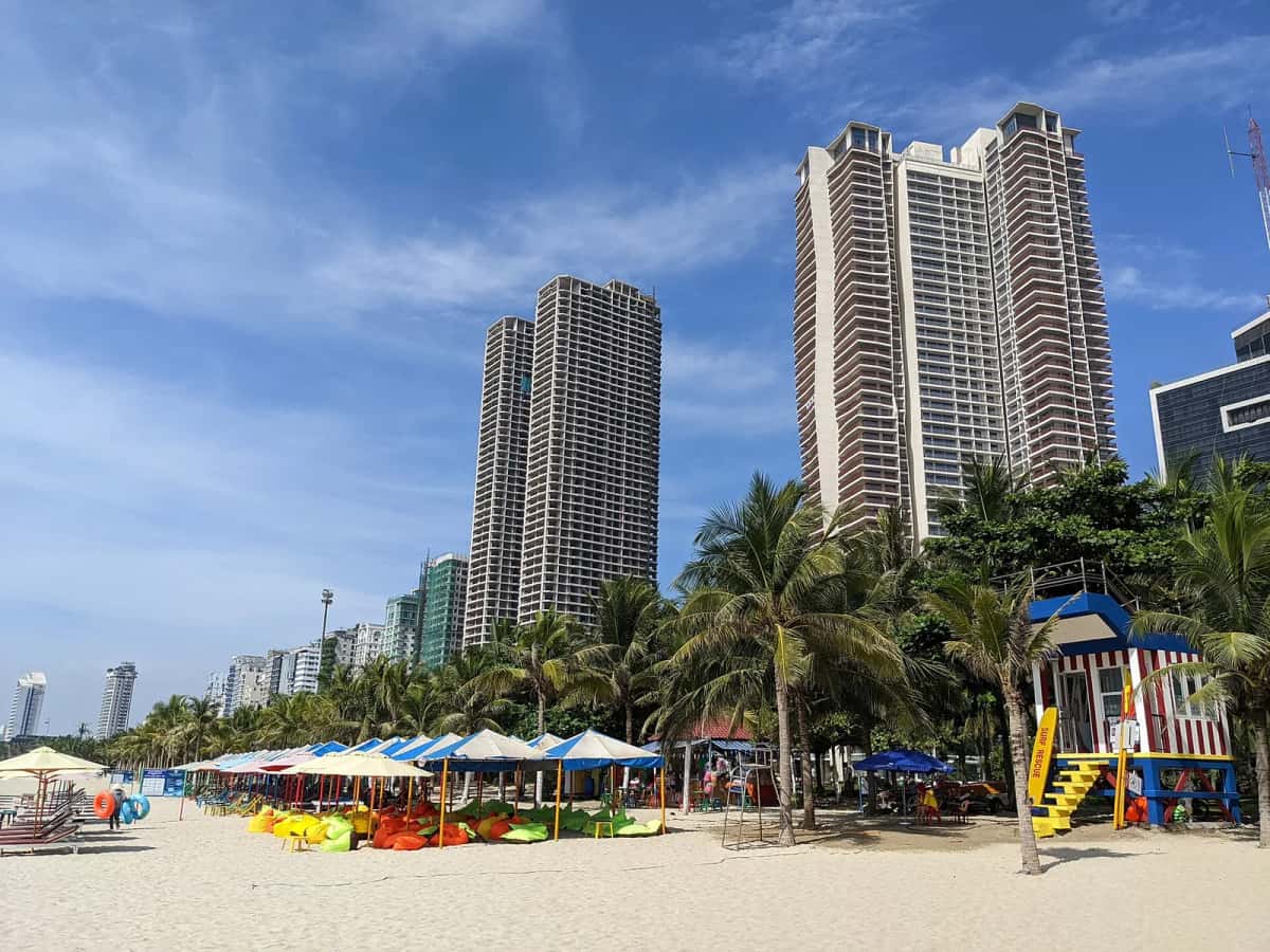 Tours d'habitation et palmiers sur la plage de My Khe, à Da Nang, sous un ciel bleu