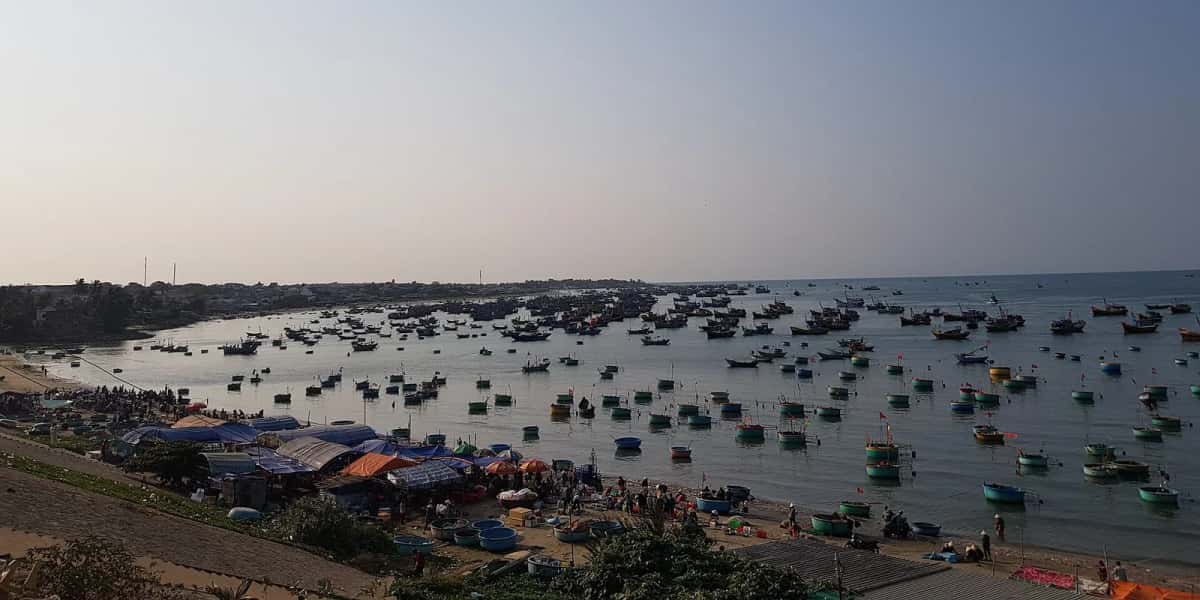 Village de pêcheurs de Mũi Né, bateaux de pêche et bateaux paniers thúng chai dans la baie