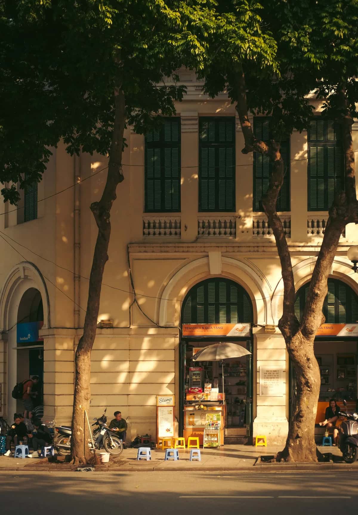Rue animée de Hanoi avec bâtiment colonial