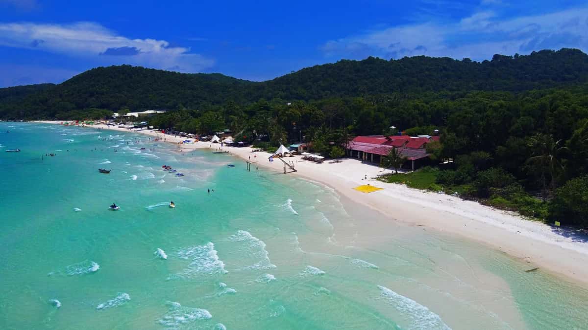 Vue aérienne de la plage de sable blanc de Bai Sao, mer turquoise et colline boisée, à Phu Quoc