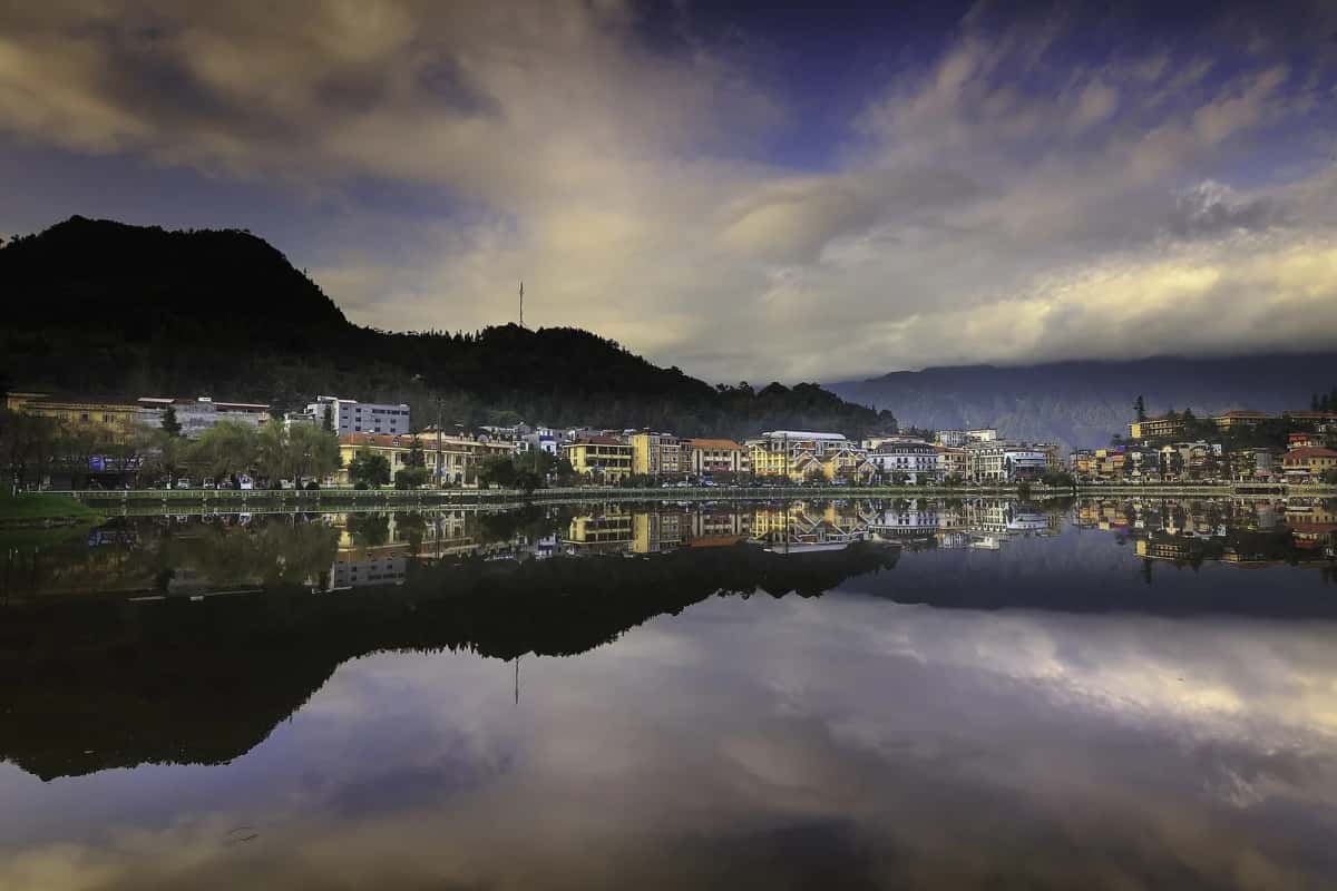Le lac et les façades de la ville de Sa Pa se reflétant au crépuscule, province de Lào Cai