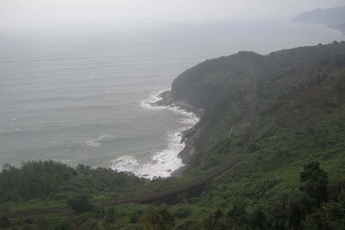 Voie ferrée Nord-Sud qui contourne une baie au col de Hải Vân, entre Huế et Da Nang